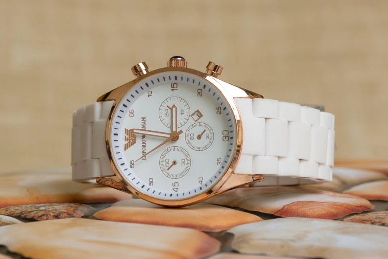 a white watch sitting on top of a pile of rocks, inspired by Edward Clark, unsplash, renaissance, michael kors, rose gold, complex background, full lenght view. white plastic