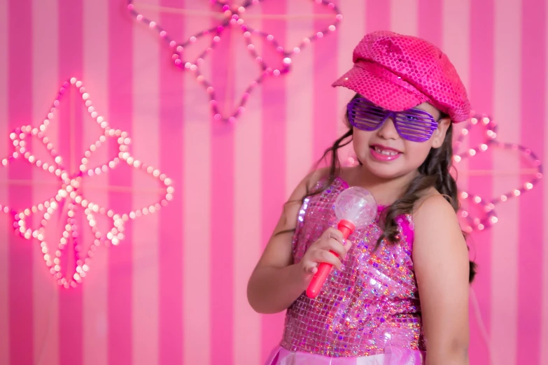 a little girl standing in front of a pink wall, an album cover, pexels, pop art, singing into microphone, wearing a fancy dress, 15081959 21121991 01012000 4k, party lights