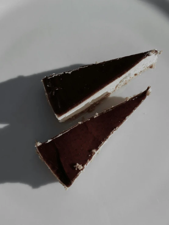 a piece of chocolate cake on a white plate, a picture, unsplash, detailed product image, two tone, triangle, natural soft rim light