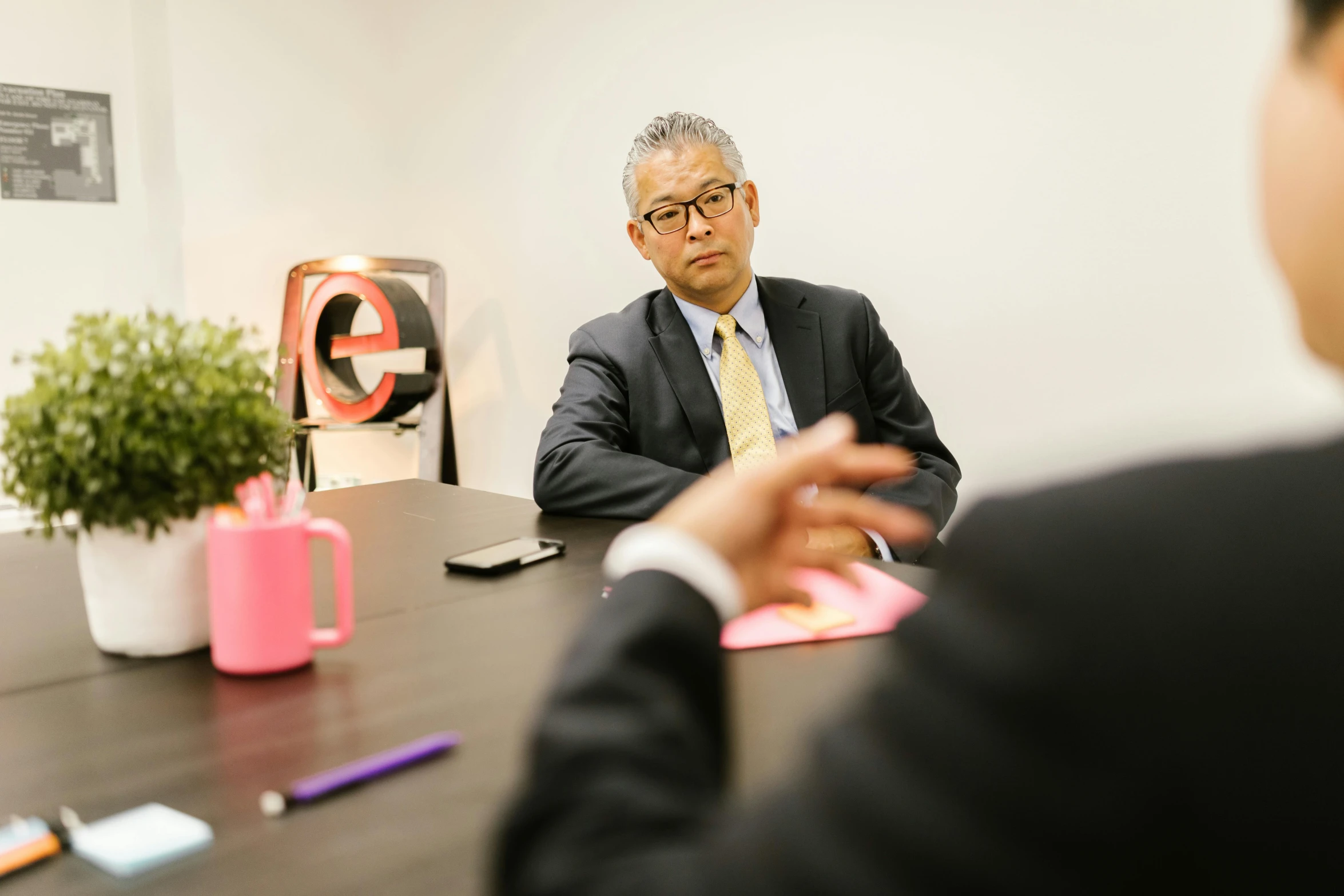 a man in a suit sitting at a table, shin hanga, eric hu, professional detailed photo, blurry image, giving an interview
