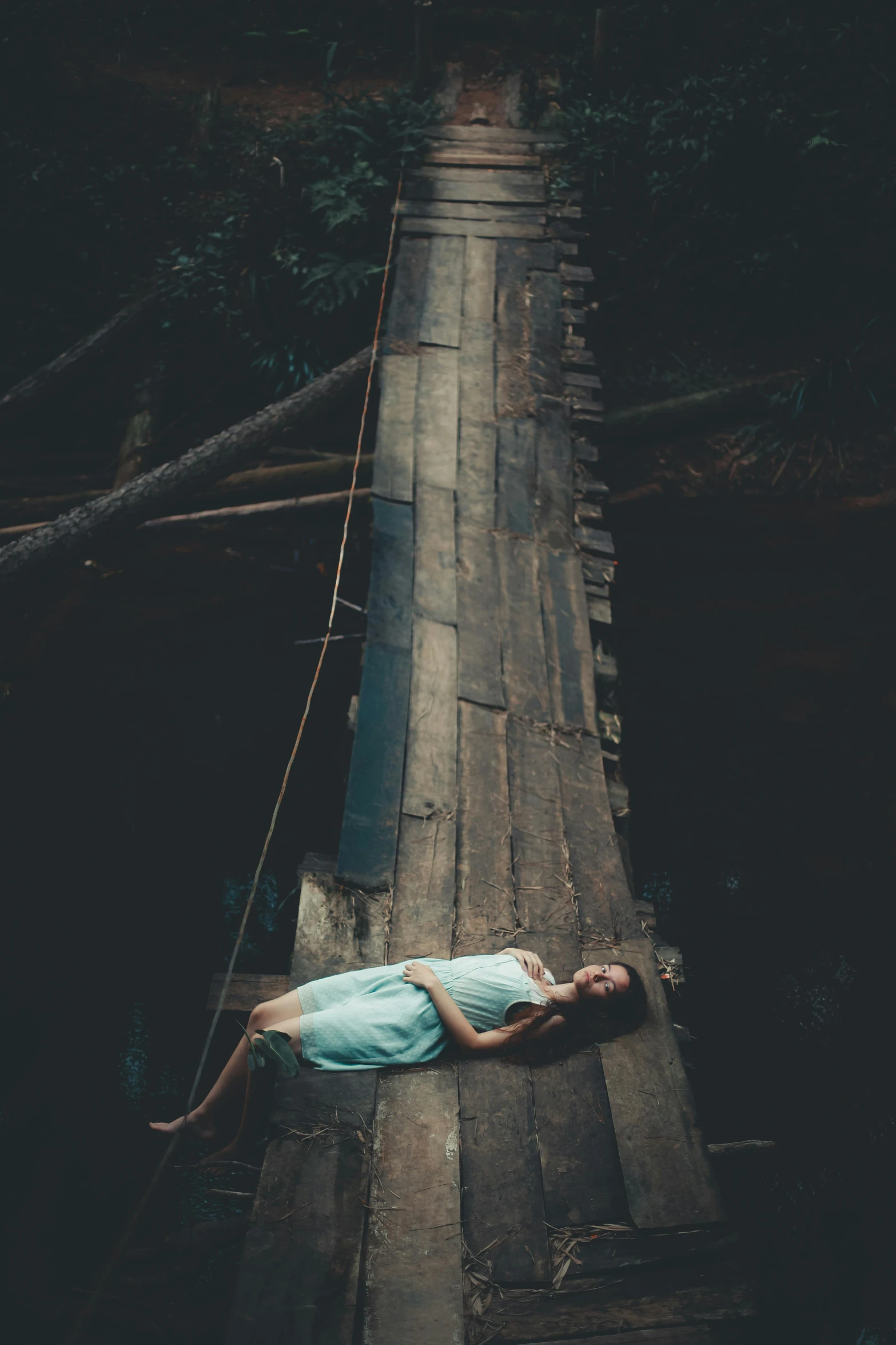 a woman laying on top of a wooden bridge, inspired by Elsa Bleda, pexels contest winner, renaissance, lost in a cave, sad man, hanging, promo image