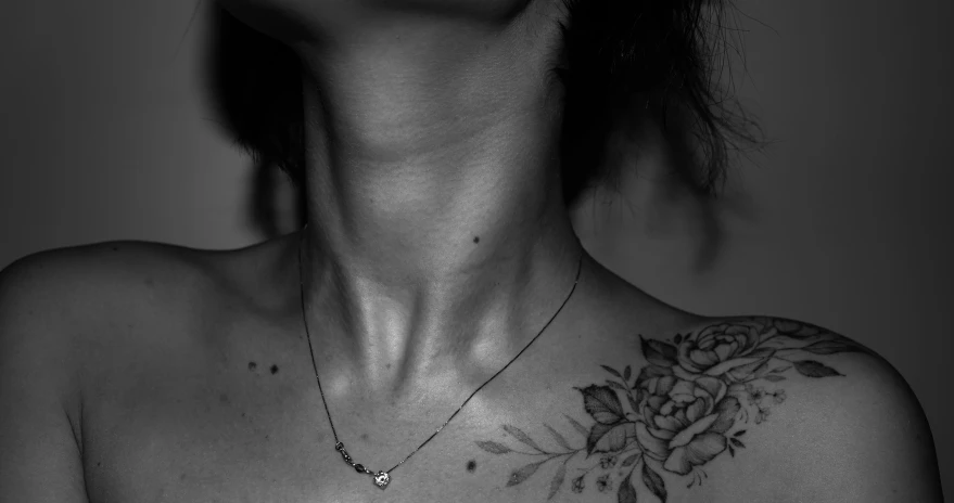 a woman with a tattoo on her chest, by Emma Andijewska, collar on neck, vascularity, minimalist, bloom