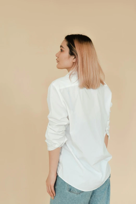 a woman wearing a white shirt and jeans, by Gavin Hamilton, pexels contest winner, minimalism, gradient hair, looking from behind, white dress shirt, detailed product image