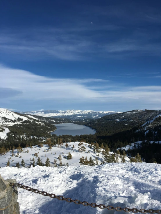 a man standing on top of a snow covered slope, by Kristin Nelson, mountain lake in sierra nevada, view from high, overlooking a valley with trees, slide show