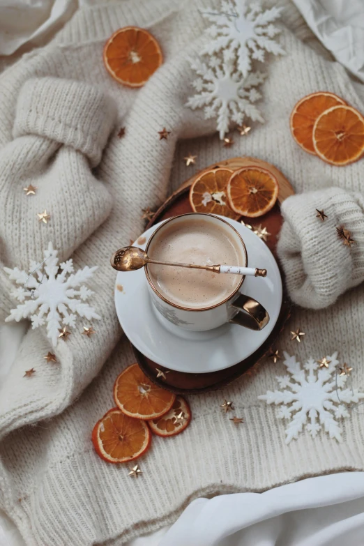 a cup of coffee sitting on top of a blanket, a picture, by Anna Haifisch, aestheticism, snowflakes, pale orange colors, 🎀 🧟 🍓 🧚, reddit post