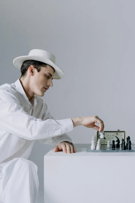 a man in a hat playing a game of chess, an album cover, inspired by Dmitry Levitzky, unsplash contest winner, in white clothes, ignant, the bauhaus, 15081959 21121991 01012000 4k