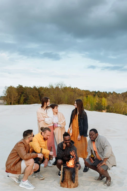 a group of people sitting around a fire pit, an album cover, by Justus van Gent, pexels contest winner, renaissance, white sand, diverse outfits, standing on a hill, belgium