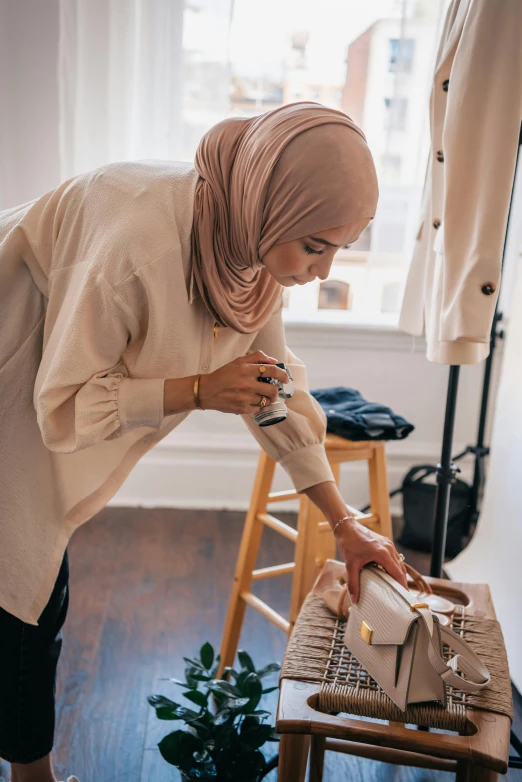 a woman in a hijab putting something in a dishwasher, pexels contest winner, cream colored blouse, at a fashion shoot, - 9, sculpting