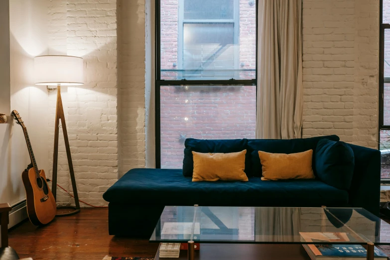 a living room filled with furniture and a large window, unsplash contest winner, dark teal couch, interior of a loft, yellow lighting from right, profile image