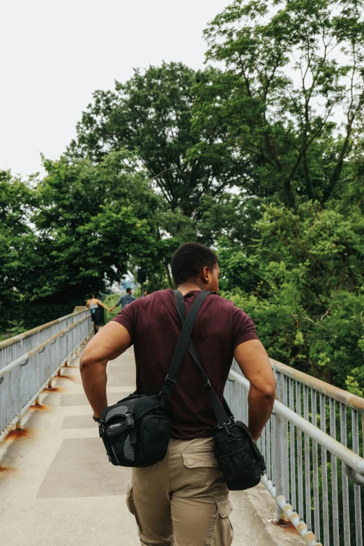 a man riding a skateboard across a bridge, a picture, pexels contest winner, happening, holding arms on holsters, dense with greenery, mid-shot of a hunky, upon a peak in darien