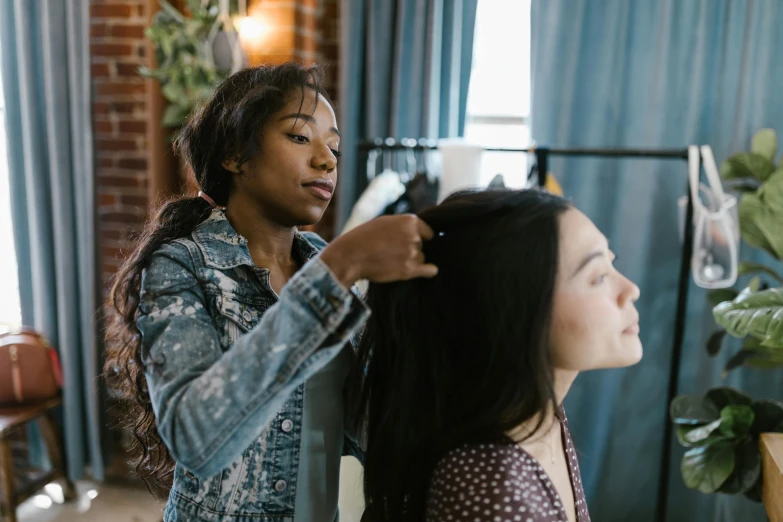 a woman combing another woman's hair in a room, trending on pexels, essence, animation, female with long black hair, behind the scenes photo