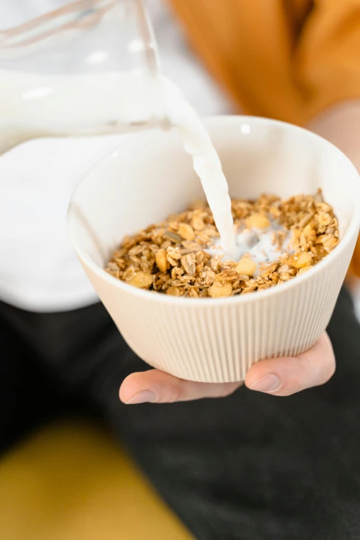 a person pouring milk into a bowl of cereal, by Nicolette Macnamara, square, high quality upload, banner, nut