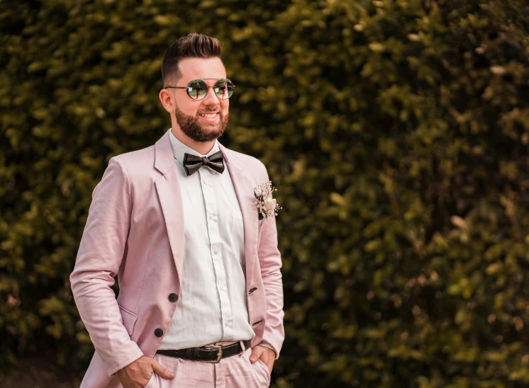 a man wearing a pink suit and bow tie, inspired by Michael Ray Charles, pexels contest winner, neo-romanticism, wedding photo, spring season, lachlan bailey, a handsome