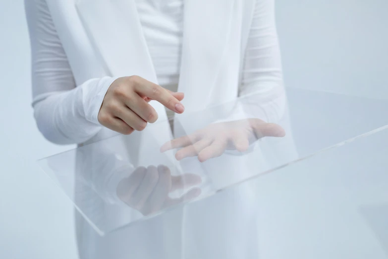 a close up of a person holding a clear object, a hologram, inspired by Anna Füssli, unsplash, interactive art, white panels, slightly minimal, tabletop model, wearing a labcoat