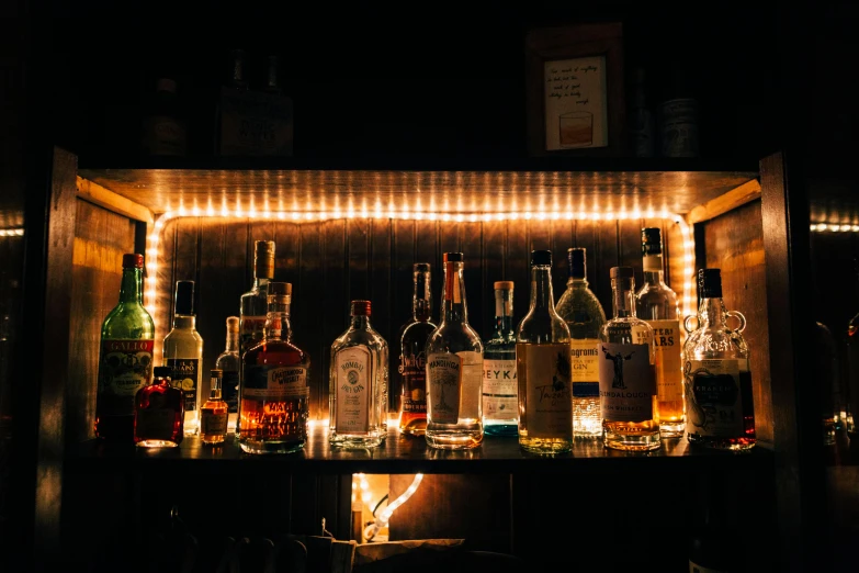 a bunch of bottles that are sitting on a shelf, pexels contest winner, saturday night in a saloon, profile image, cosy vibes, lit up