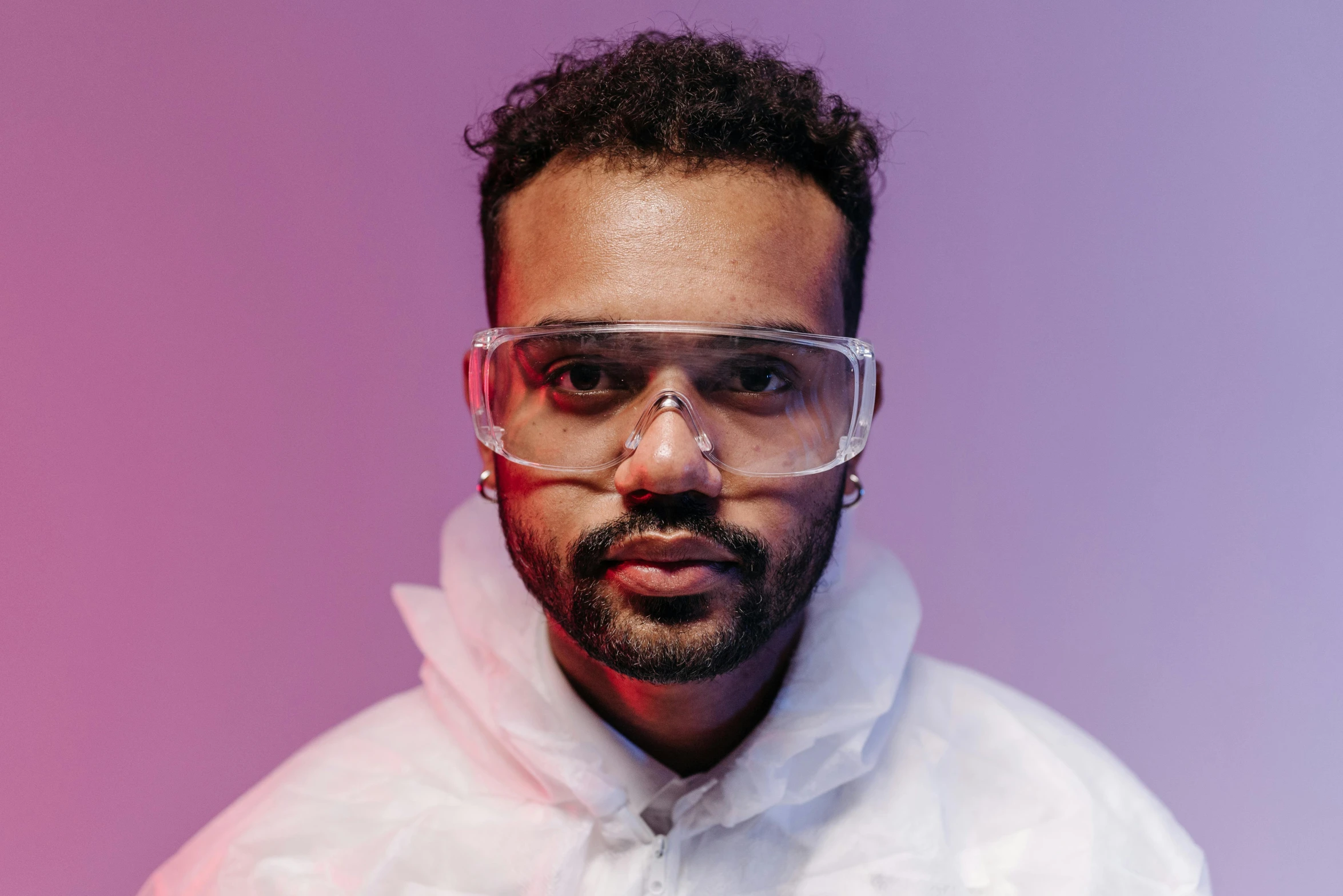 a man in a white hoodie and goggles, an album cover, inspired by Ismail Gulgee, pexels contest winner, foxish guy in a lab coat, jeffrey wright, lgbtq, portrait image