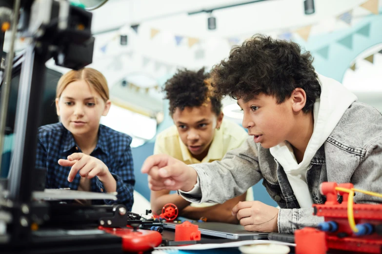 a group of young people working on a project, trending on pexels, ashcan school, robotic arm, avatar image, teenage boy, focused photo