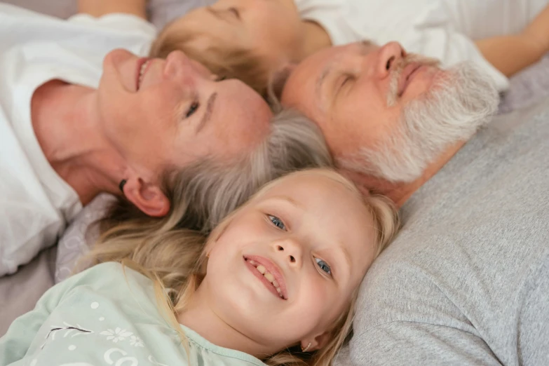 a group of people laying on top of a bed, grey beard, family friendly, age lines, coloured