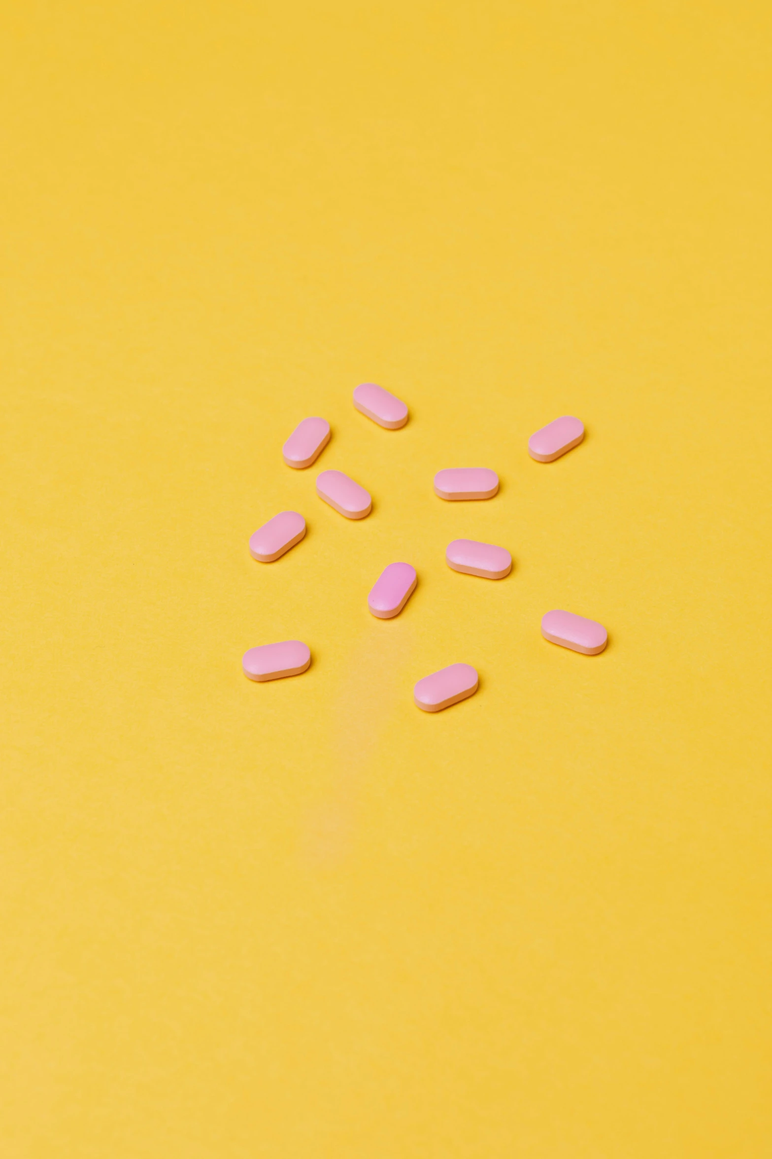 pink pills on a yellow background, by Anita Malfatti, unsplash, antipodeans, tiny sticks, on a gray background, slightly pixelated, orelsan