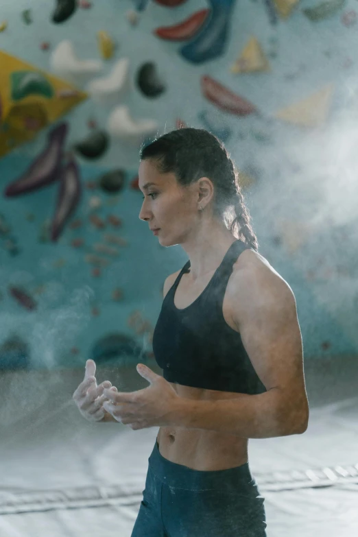 a woman standing in front of a climbing wall, a portrait, pexels contest winner, process art, sweaty. steam in air, promo image, in a gym, water mists