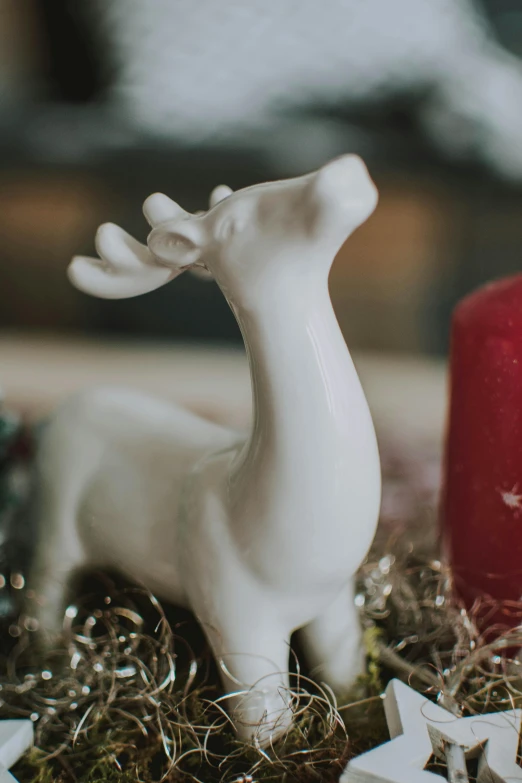 a close up of a deer figurine on a table, inspired by Rudolph F. Ingerle, unsplash, white candles, made of glazed, soap, regular sized