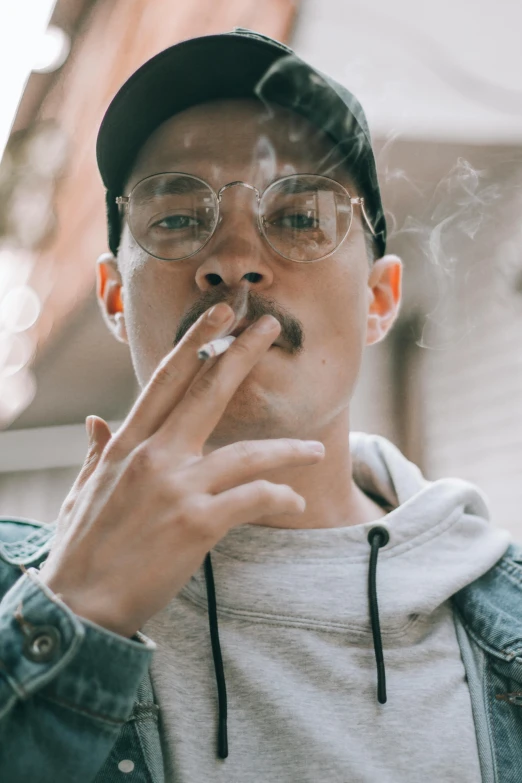 a man with glasses smoking a cigarette, inspired by Jeremy Chong, trending on pexels, grey mustache, hip hop aesthetic, instagram story, androgynous person