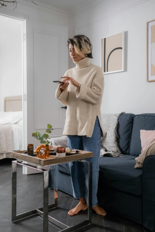 a woman standing in a living room next to a couch, by Android Jones, trending on pexels, happening, breakfast, wearing turtleneck, samsung smartthings, carrying a tray