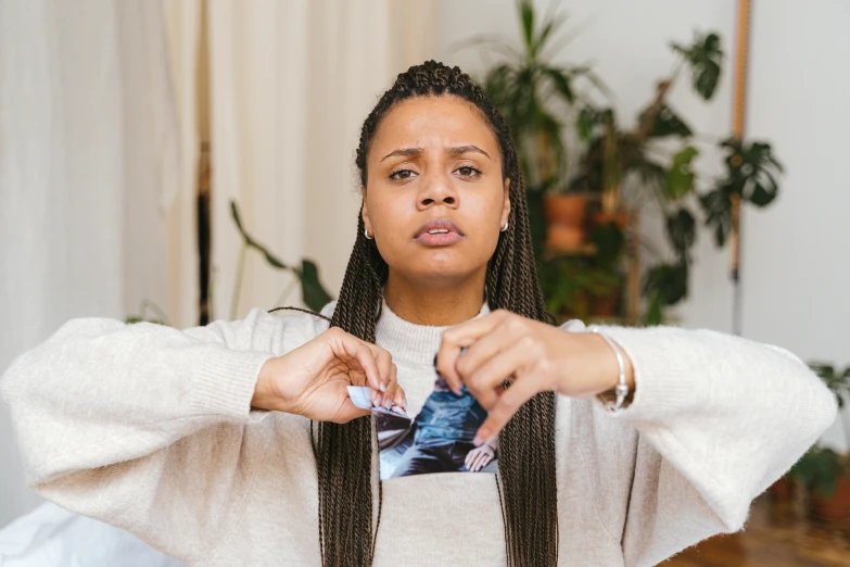 a woman making a funny face with her hands, a polaroid photo, by Julia Pishtar, happening, tessa thompson inspired, pregnancy, holding ace card, looking sad