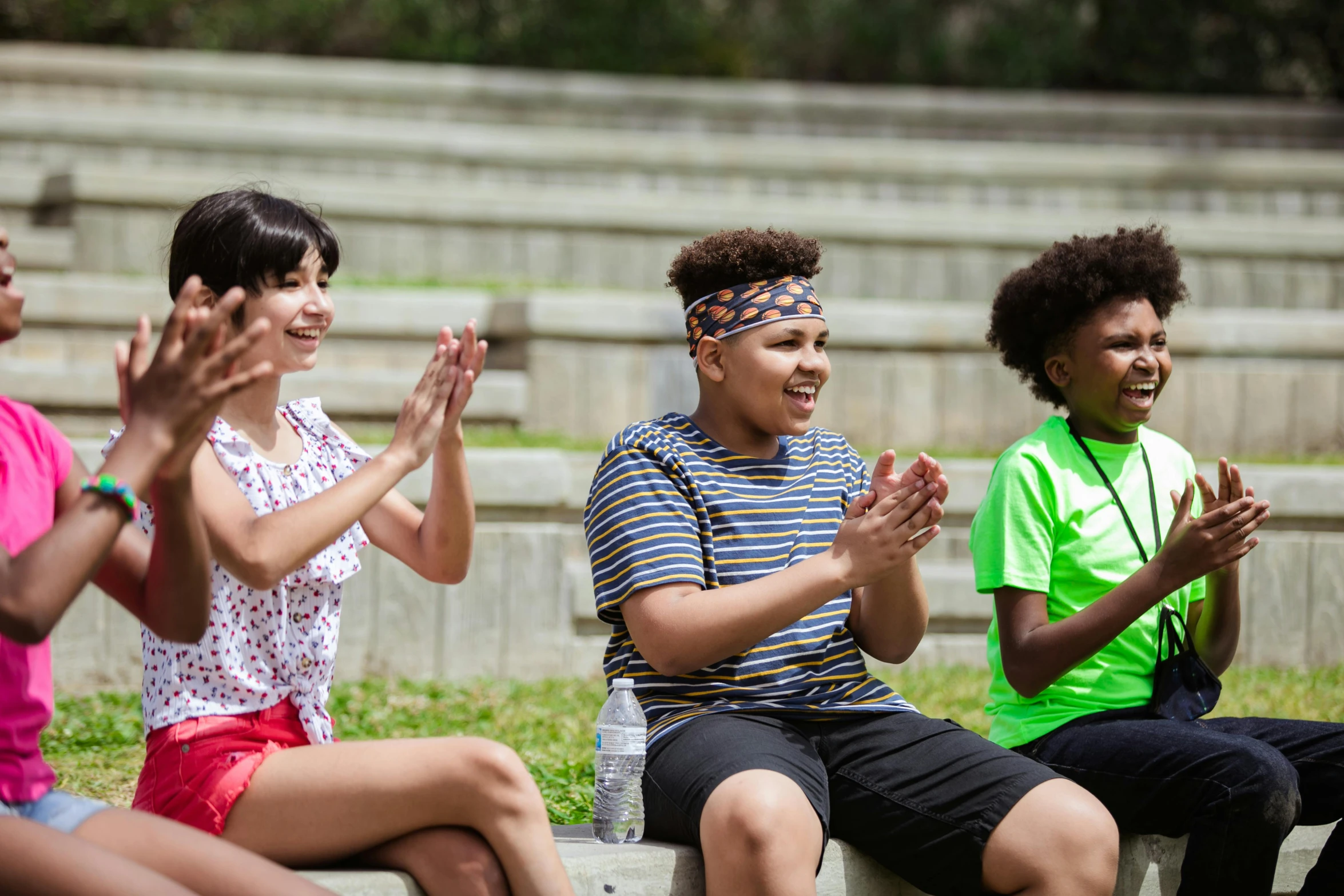 a group of people sitting on top of a cement bench, hands in air, summer camp, avatar image, actors