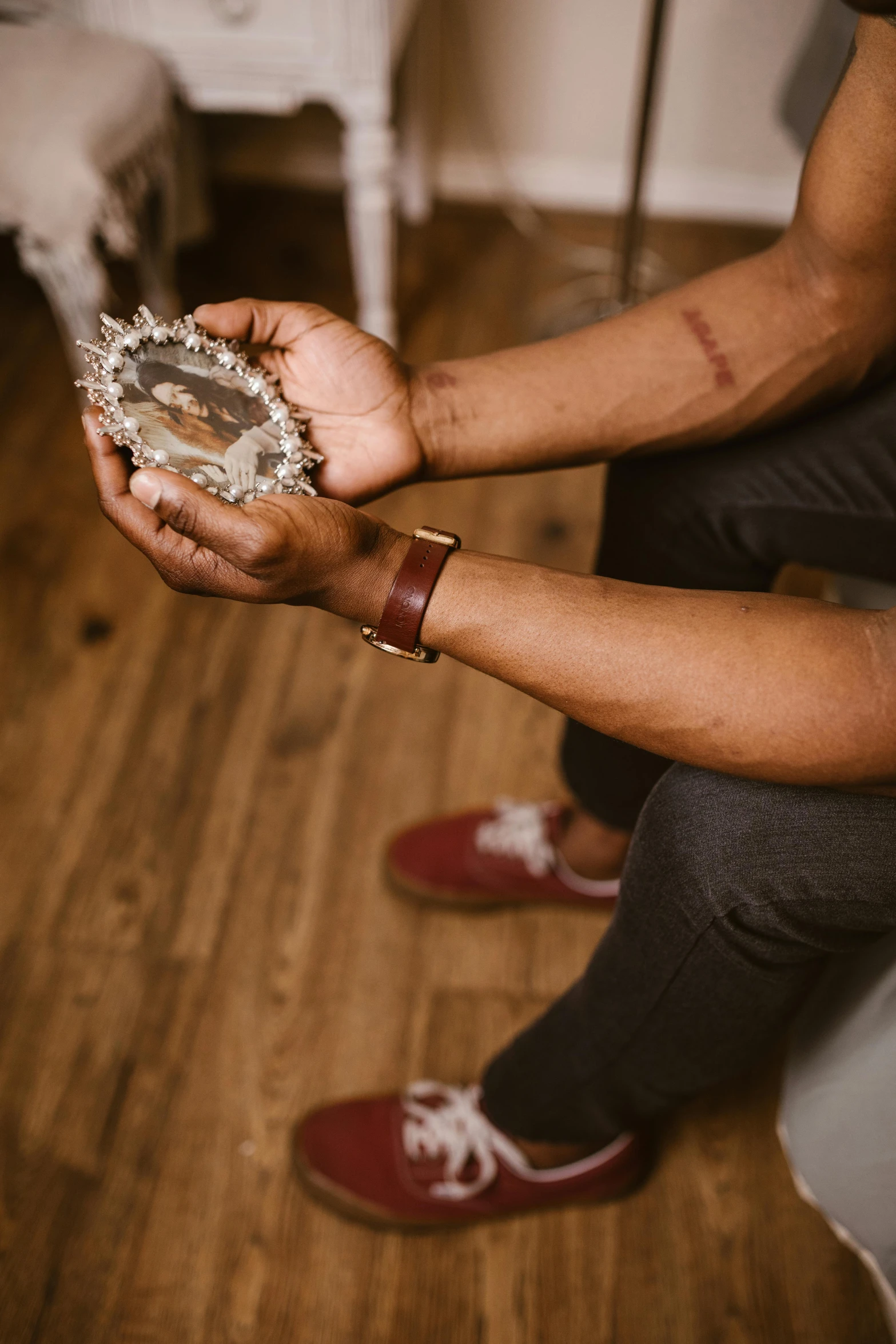 a man sitting on a toilet holding a piece of tin foil, by Nina Hamnett, trending on pexels, black arts movement, ornate and intricate jewelry, on a wooden table, looking into a mirror, geode