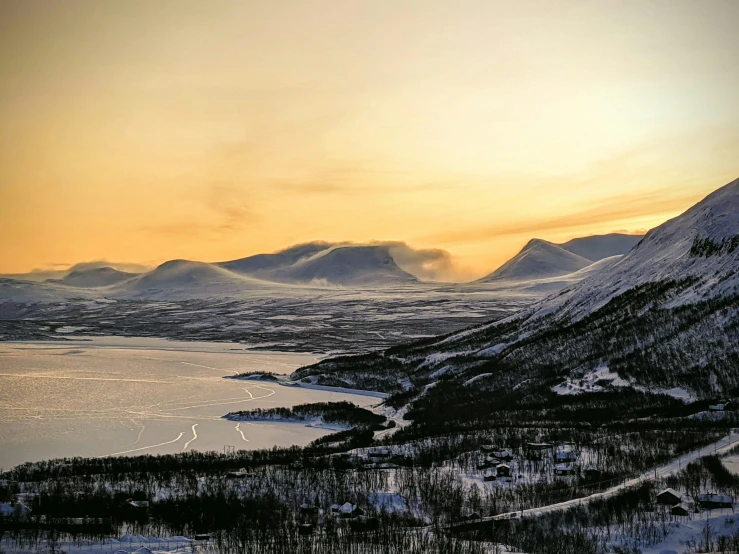 a large body of water surrounded by snow covered mountains, by Anton Lehmden, pexels contest winner, hurufiyya, sunset in a valley, scandinavian / norse influenced, overlooking a valley with trees, grey