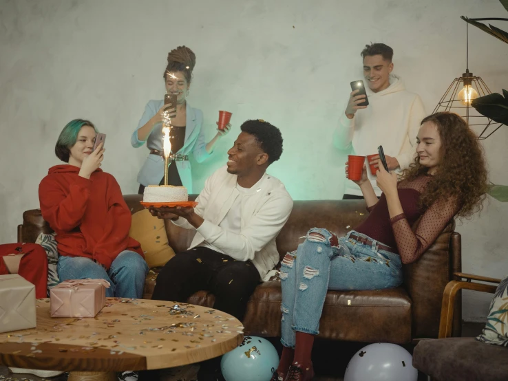 a group of people sitting on top of a couch, trending on pexels, happening, birthday cake on the ground, 2 1 savage, high quality photo, hd footage