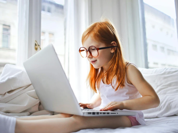 a little girl sitting on a bed using a laptop computer, pexels, amber glasses, hr ginger, thumbnail, game resources