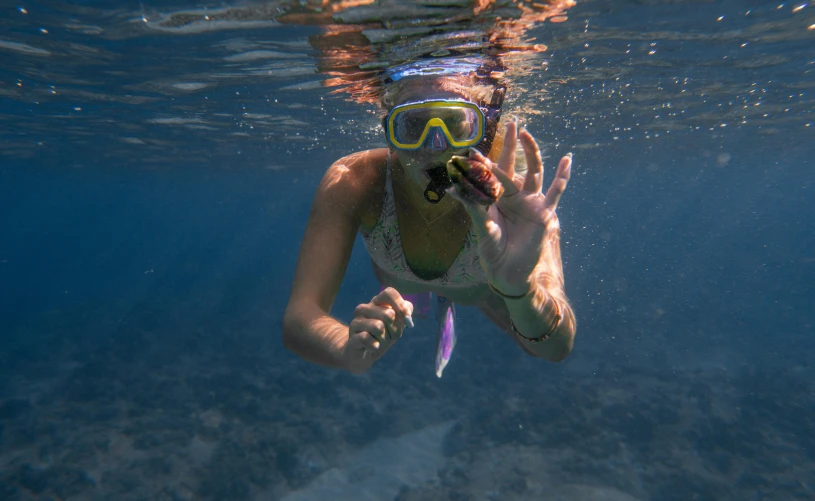 a woman swimming in the ocean with a mask on, by Jessie Algie, pexels contest winner, coral underwater colorful, finger, pirates, aussie