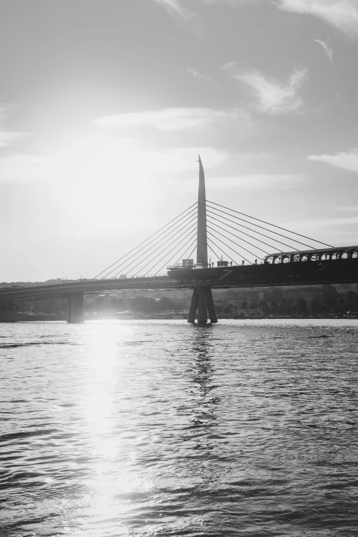 a black and white photo of a bridge over a river, by Gusztáv Kelety, in the sun, detailed medium format photo, skyline, 15081959 21121991 01012000 4k