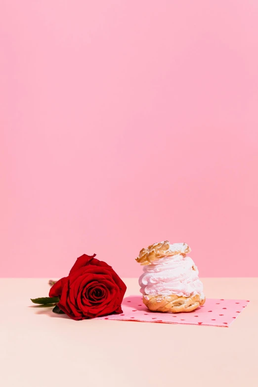 a cupcake sitting on top of a table next to a red rose, a still life, by Julia Pishtar, romanticism, pink and gold, ice cream on the side, official product photo, crisp contour - lines