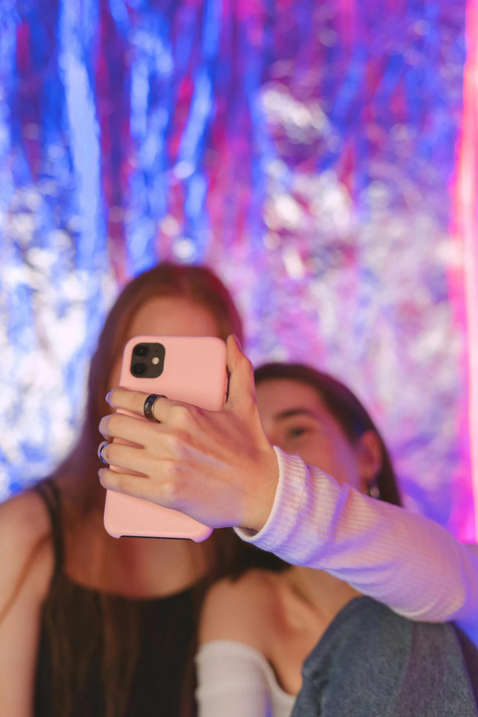 a woman taking a picture with her cell phone, by Robbie Trevino, happening, neon background lighting, older sister vibes, 🎀 🍓 🧚, editorial image