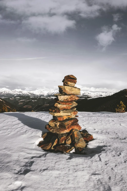 a stack of rocks sitting on top of a snow covered slope, inspired by Andy Goldsworthy, unsplash contest winner, hiking in rocky mountain, today\'s featured photograph 4k, chimney, heaven on earth