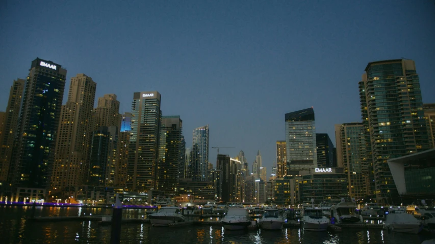 a harbor filled with lots of boats next to tall buildings, a picture, hurufiyya, night outside, dubai, documentary photo, image