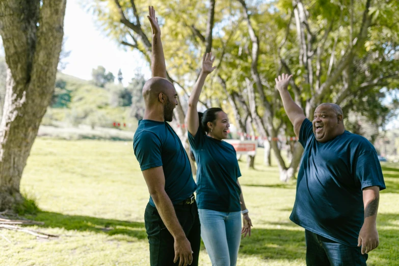 a group of people standing on top of a lush green field, at a park, 5k, shrugging arms, profile image