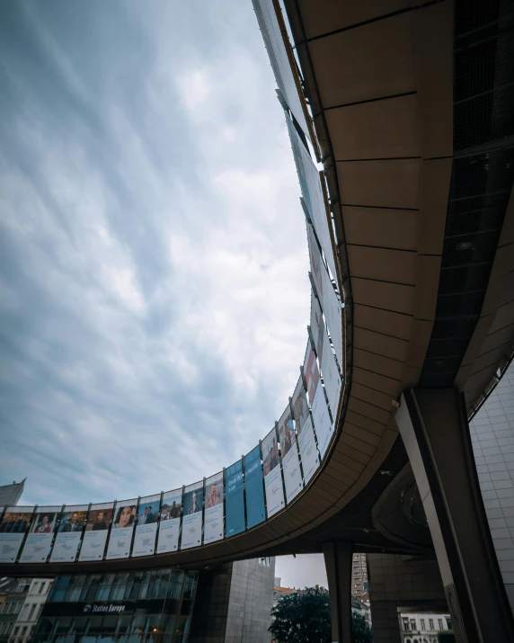 a man riding a skateboard up the side of a ramp, inspired by Tadao Ando, unsplash contest winner, brutalism, round clouds, on a futuristic shopping mall, 3/4 view from below, in tokio