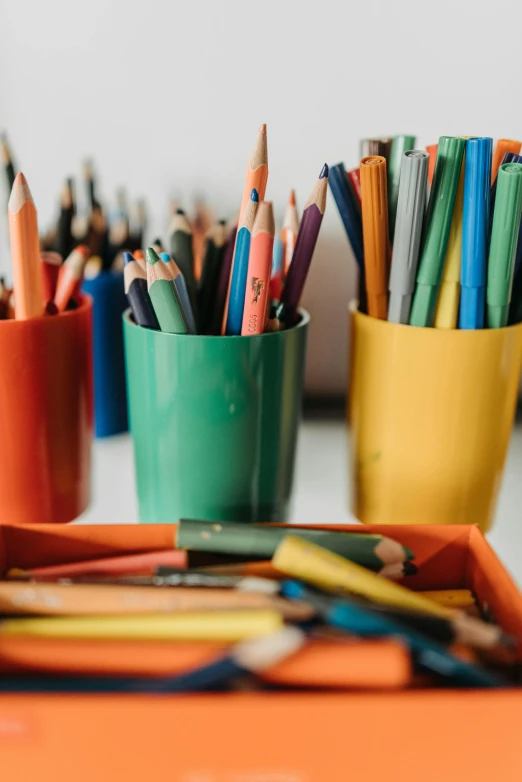 a table topped with lots of different colored pencils, pexels, arts and crafts movement, photo of a classroom, chartreuse and orange and cyan, no - text no - logo, ilustration