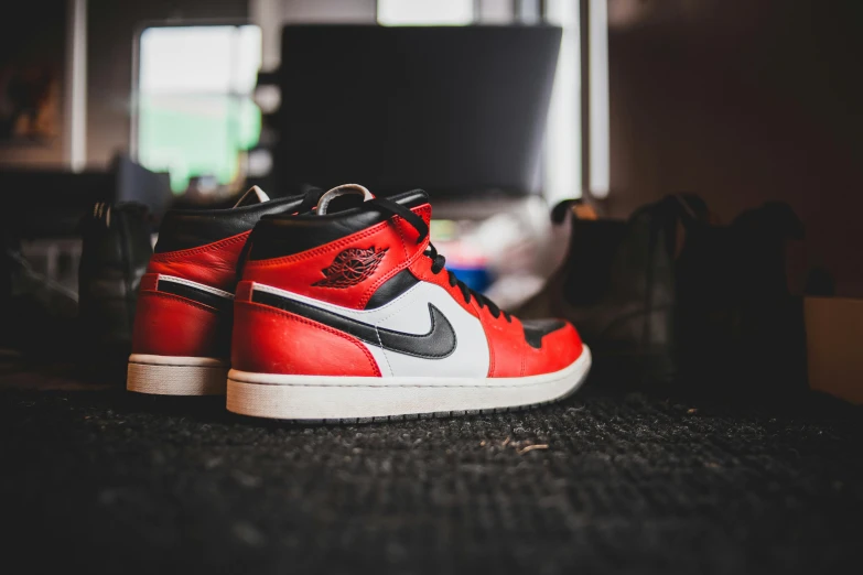 a pair of sneakers sitting on top of a carpet, inspired by Jordan Grimmer, trending on pexels, hyperrealism, red white and black, profile shot, “air jordan 1, red and white neon