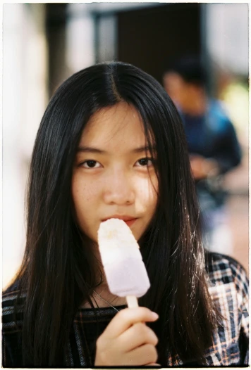 a close up of a person holding a popsicle, by Tan Ting-pho, young woman with long dark hair, lovingly looking at camera, song nan li, ice cream on the side