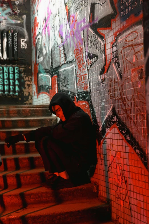 a man sitting on top of a set of stairs, pexels contest winner, graffiti, wearing sith hood, kylo ren, deep in thought, nightlife