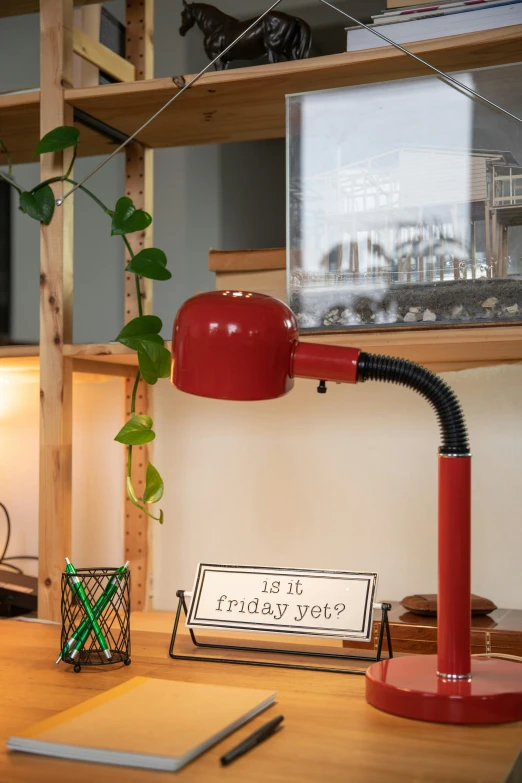 a red desk lamp sitting on top of a wooden desk, quirky shops, studio kyoto, holiday, studio 4°c