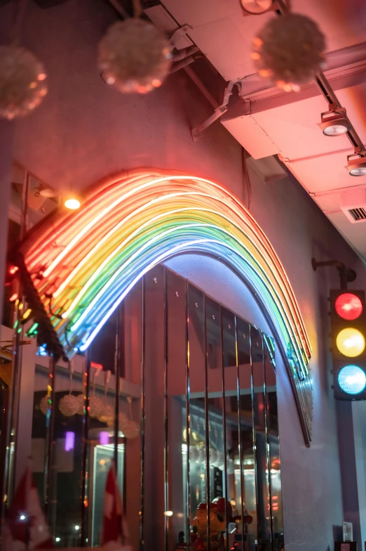 a group of people walking down a street next to a traffic light, by Rachel Reckitt, kinetic art, rainbows, neon shops, electricity archs, rick dai