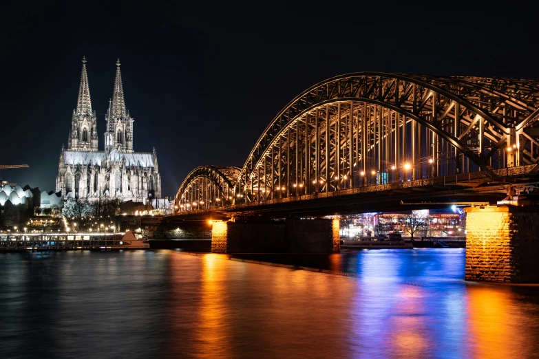 a bridge over a river with a cathedral in the background, by Tom Wänerstrand, pexels contest winner, vibrant lights, grey, panorama, brown