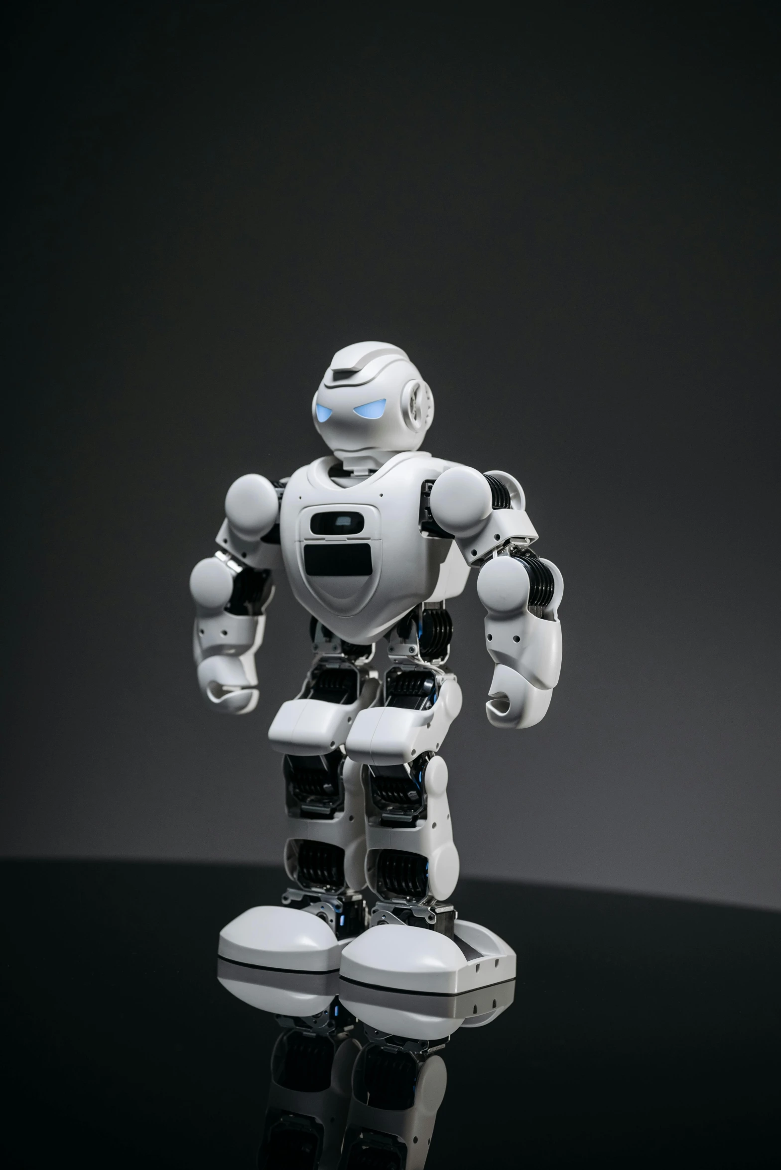 a robot that is standing on a table, on a black background, on a white table, promo image, anato finnstark. front view