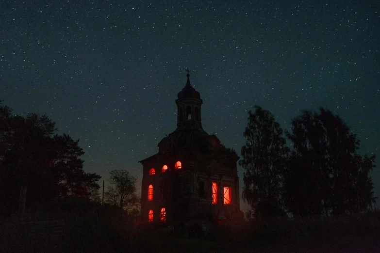 a church lit up at night with stars in the sky, an album cover, by Attila Meszlenyi, pexels contest winner, old abandoned house, red and orange glow, abandoned circus, an abandoned old